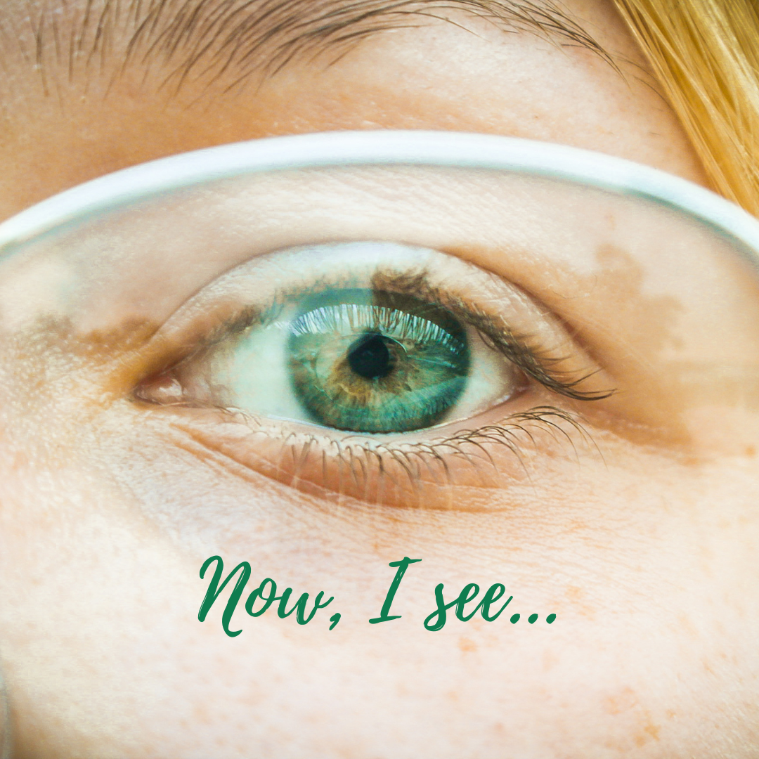 Green eye behind eyeglasses. 