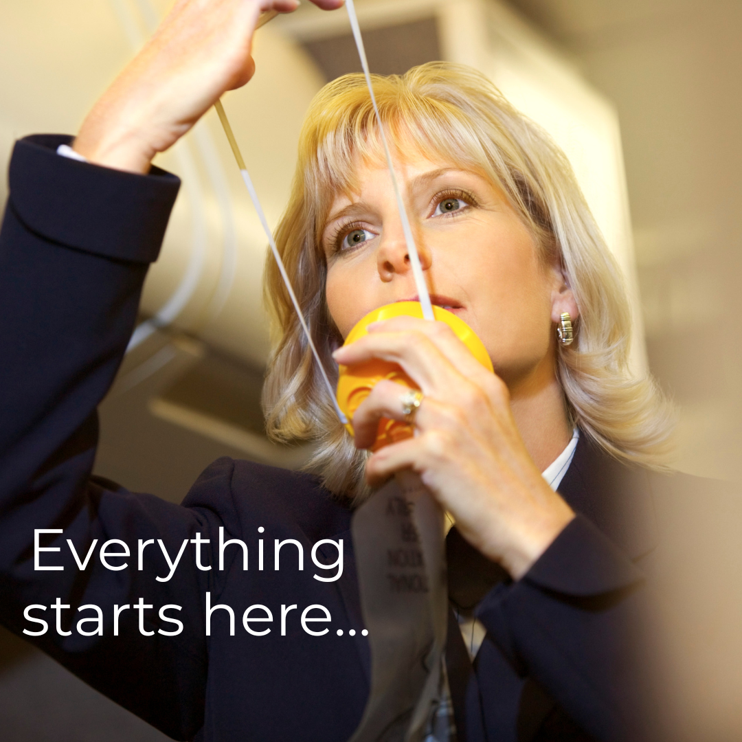 Female flight attendant demonstrating oxygen mask use